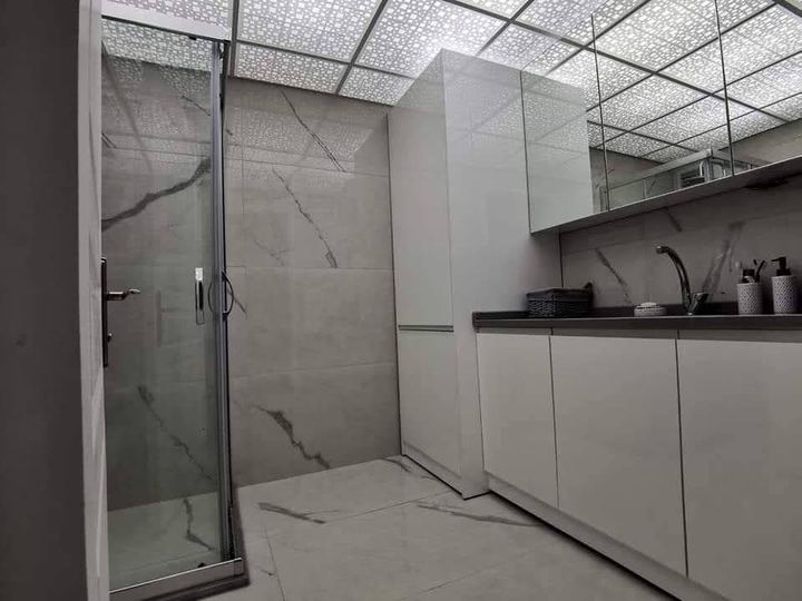 Beyaz dolaplı banyo, cam duşakabin ve dekoratif asma tavan