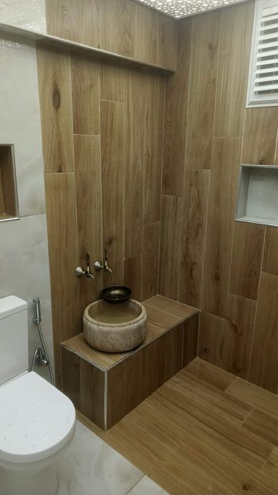 Ahşap görünümlü fayanslı banyo, kurna ve duvar nişi