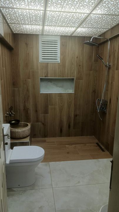 Banyo tadilatı sonrası genel görünüm: duş alanı, kurna ve klozet