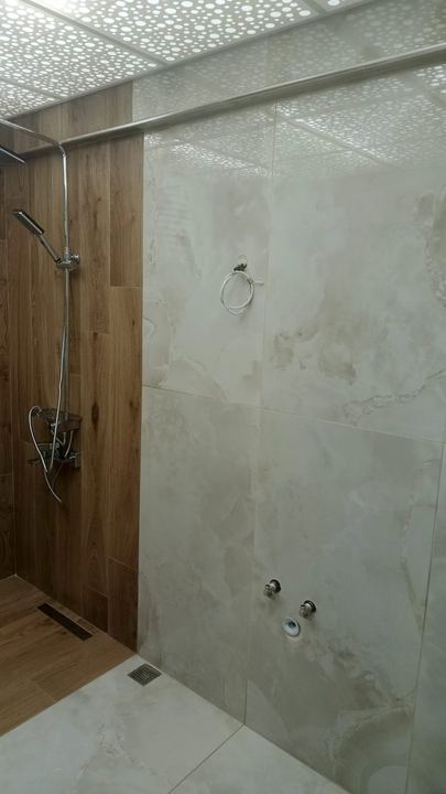 Ahşap ve krem mermer görünümlü fayans birleşimi, duş alanı